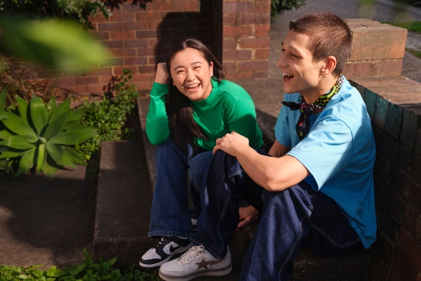 two young people sitting together and laughing