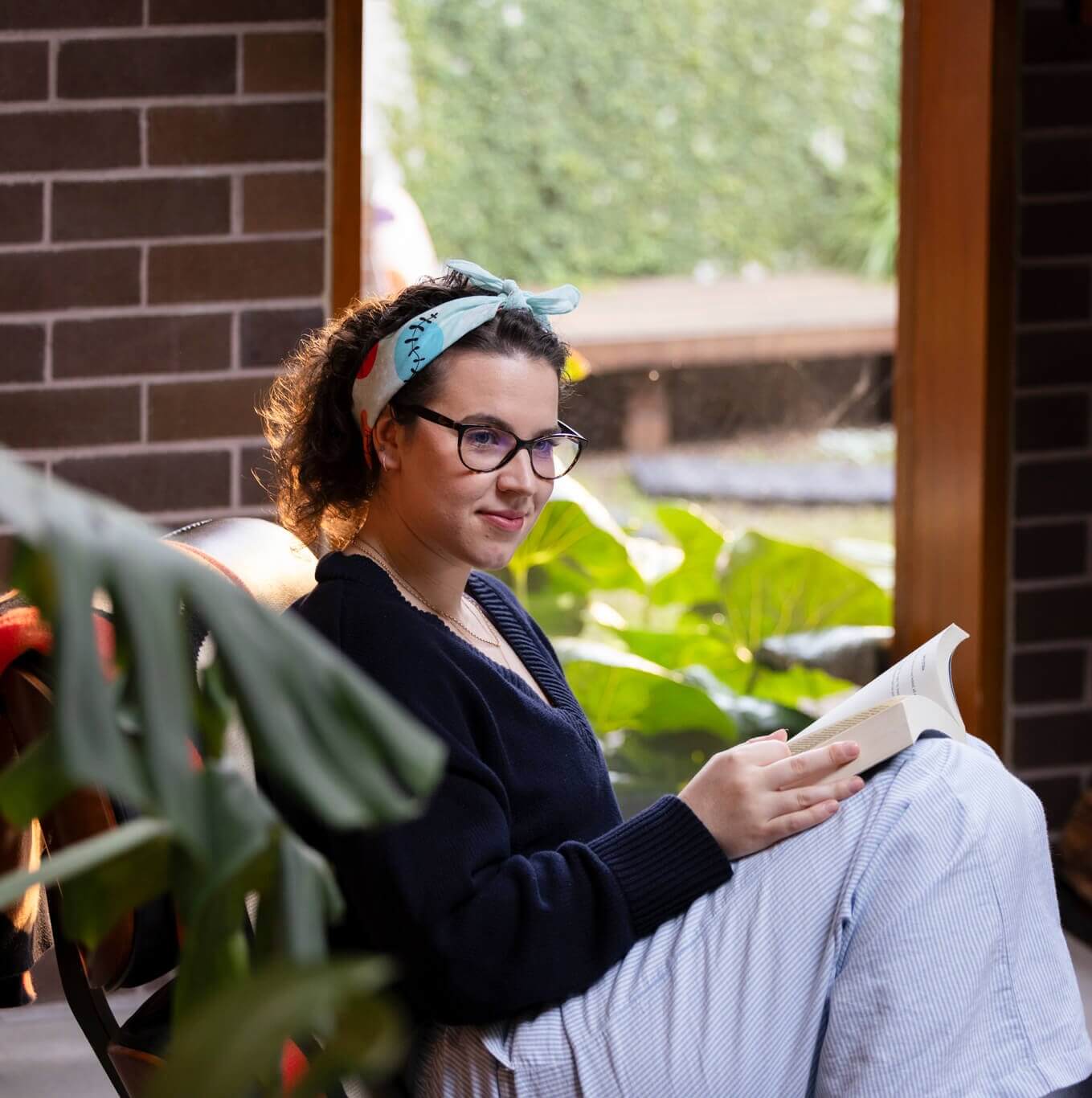 saskia, a young person impacted by cancer, sitting and reading